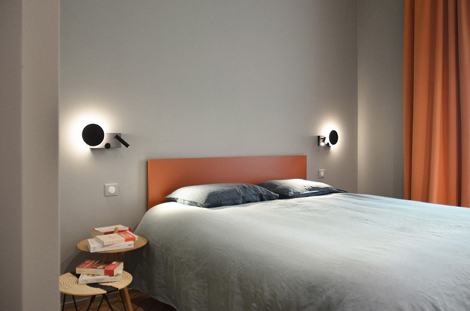 Projet Mignard : détail sur une tête de lit sur mesure avec liseuses conçue par une architecte intérieur