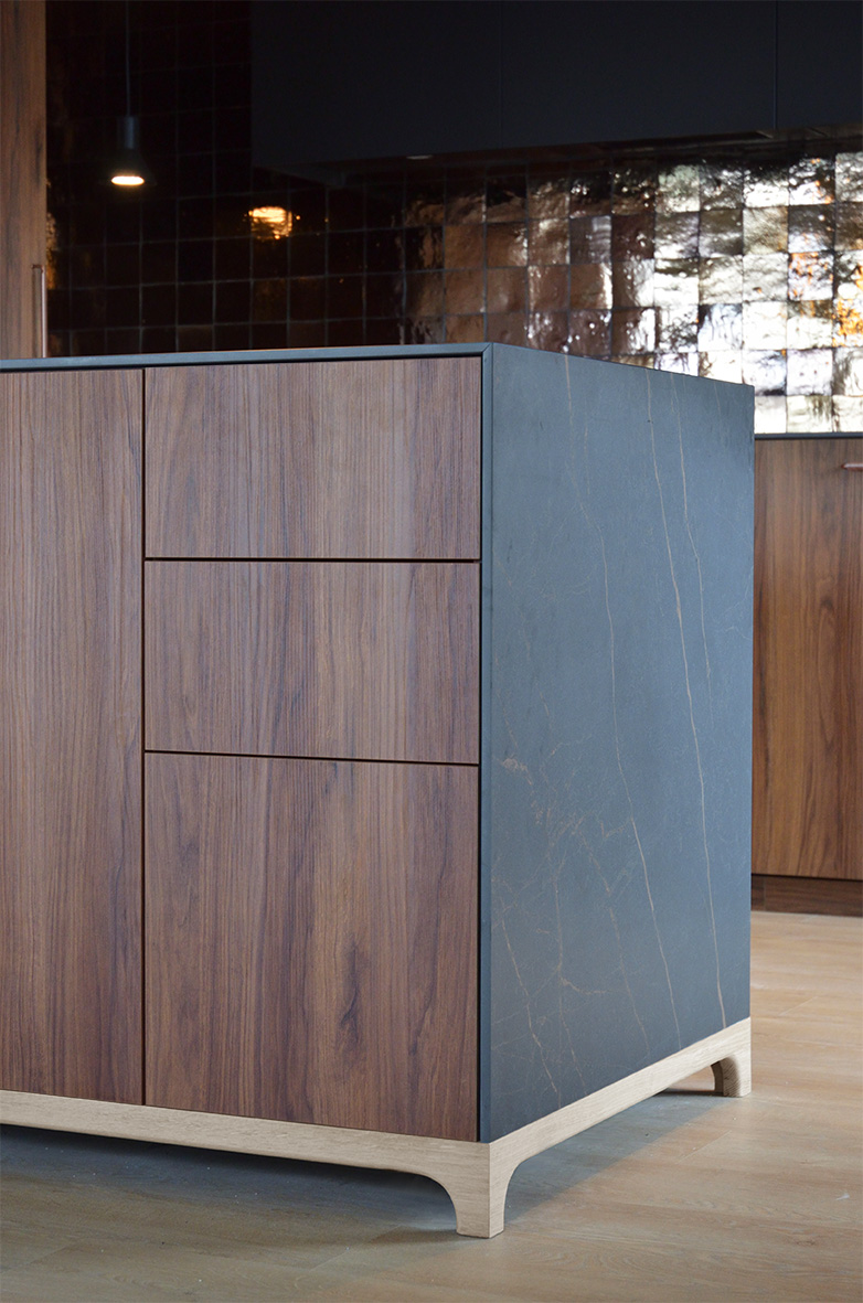 Cuisine sur mesure couleur noyer avec un plan de travail en grès cérame Neolith Mamba reposant sur un pied couleur chêne sur mesure